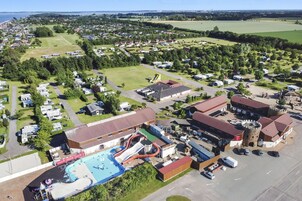 Vista aérea de un camping con piscina, parque acuático y varias construcciones.