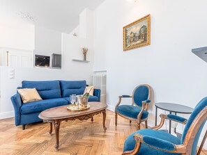 A living room with a blue sofa, a wooden coffee table, and two blue armchairs.