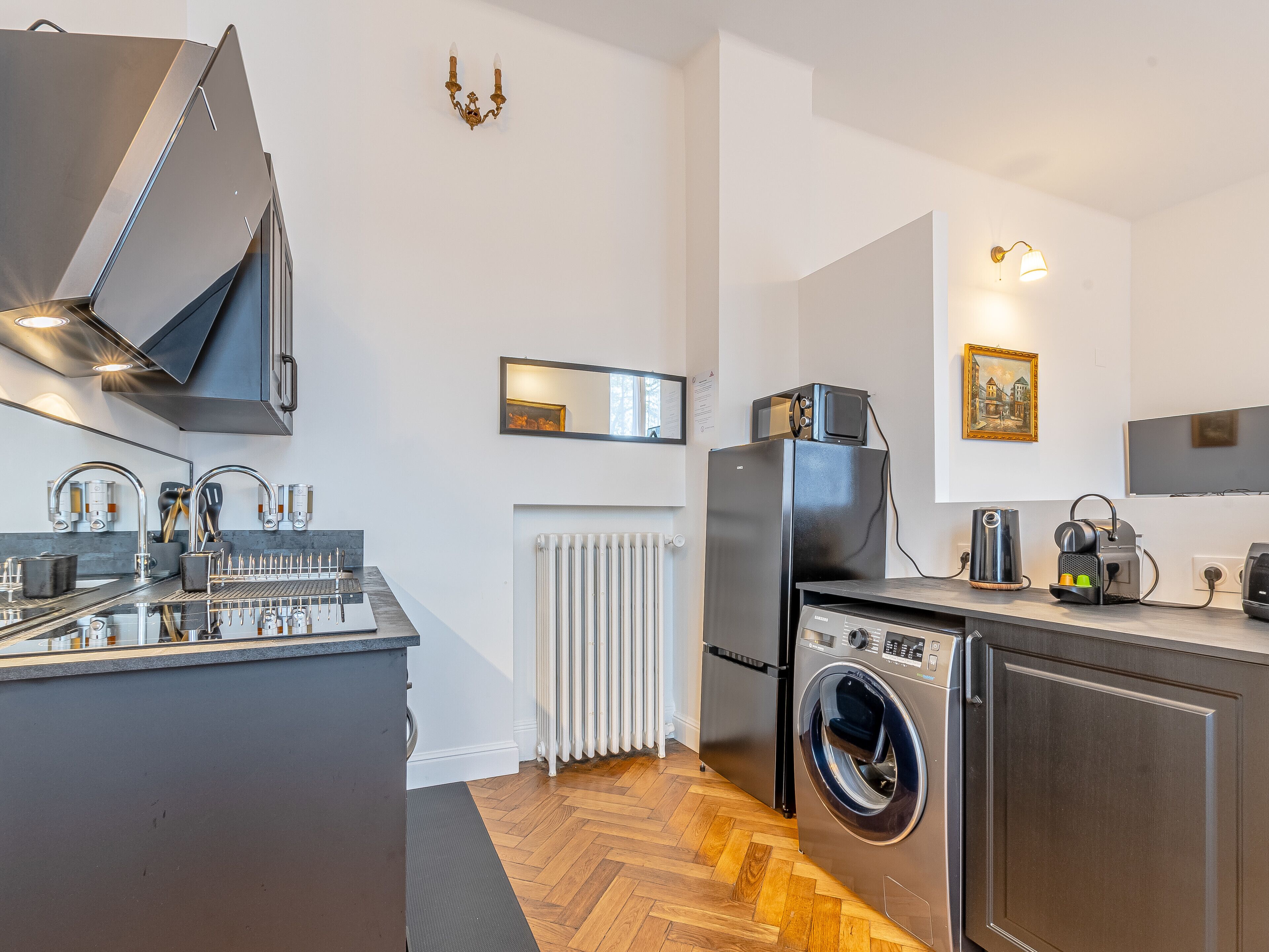Eine moderne Küche mit Einbauherd, Mikrowelle, Kühlschrank und Waschmaschine.