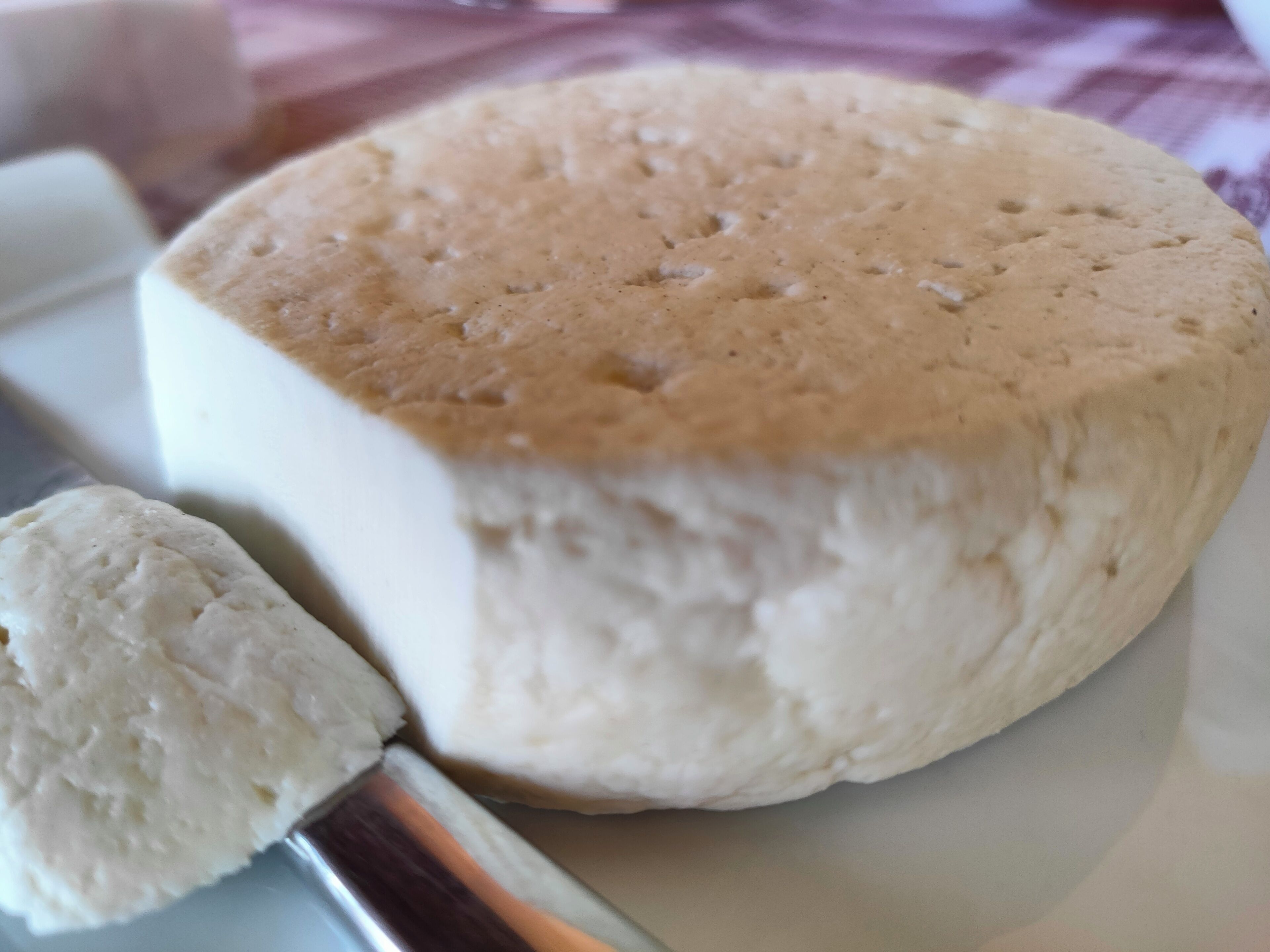 A large wheel of cheese on a plate.