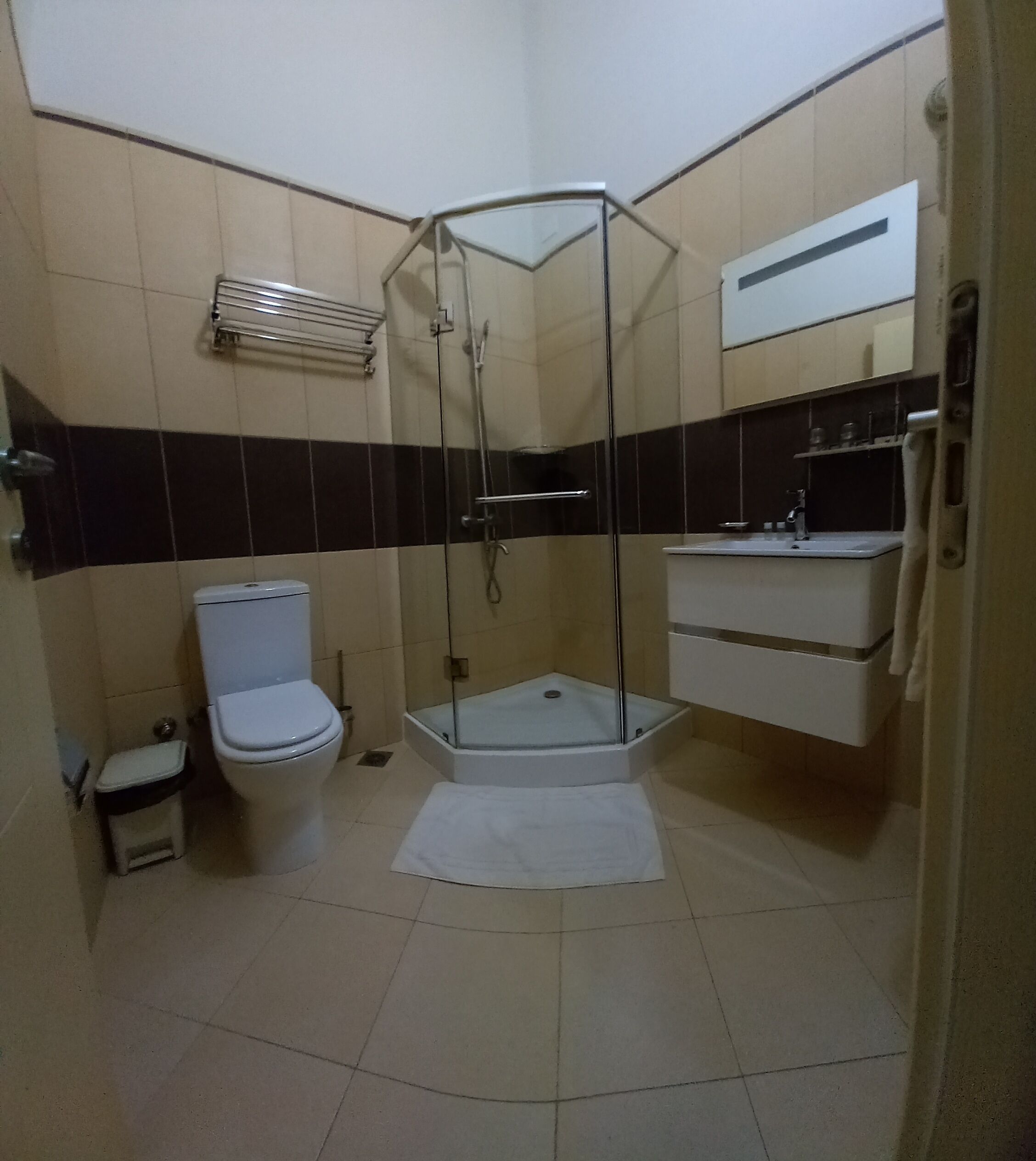 Un baño con inodoro, cabina de ducha y lavamanos.