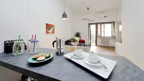 Eine moderne Küche mit grauer Arbeitsplatte, einer Kaffeemaschine, zwei Tassen und einem Tablett mit Gebäck.