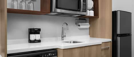 A modern kitchen with stainless steel appliances, a coffee maker, and a dishwasher.