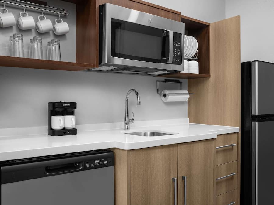 A modern kitchen with stainless steel appliances, a coffee maker, and a dishwasher.