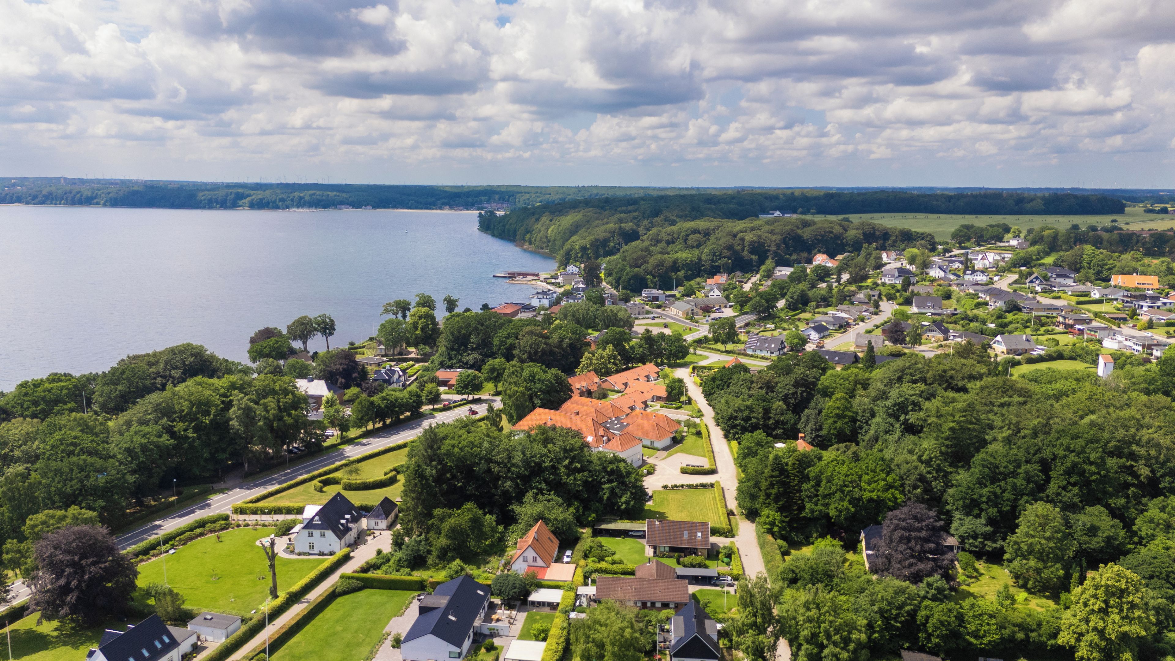A residential area with houses, a road, and a body of water.