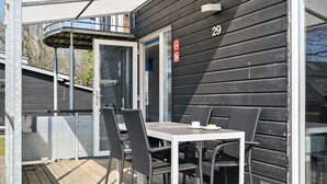 A covered outdoor area with a table and chairs, a sliding glass door, and a number '29' on the wall. - First Camp Frigard   Flensborg Fjord (Krusaa)
