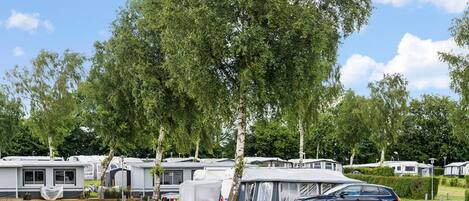 A caravan park with multiple caravans and a black car parked in the foreground.