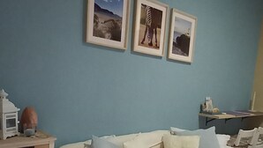 Un dormitori amb dos llits, un aparador i quadres penjats a la paret.