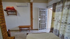 Enjoy a simple, serene space with a bed, bench, and door with a decorative gate.