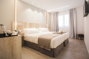 A modern hotel room with a large bed, bedside tables, a flat-screen TV, and a wooden floor. - DWO Ábaster (Soria)
