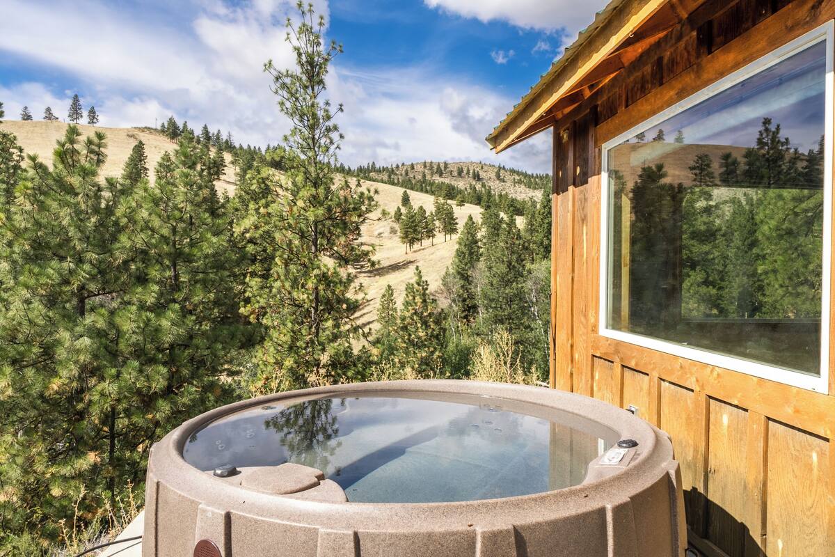 A hot tub with a clear view of a mountainous landscape.