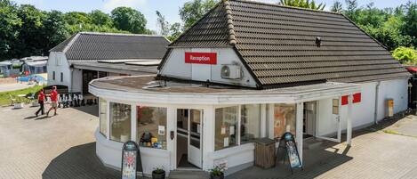 A reception area with a sign, a counter, and a window displaying items.