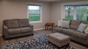 A living room with two sofas, a coffee table, and a patterned rug.