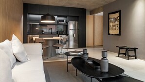 Loftsrom – elite, 1 soverom, balkong | Oppholdsområde | En 65-tommers smart-TV med kabel-kanaler samt TV