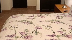 Une chambre à coucher comprenant un lit, une armoire, une table de chevet, une lampe et un appareil de climatisation.