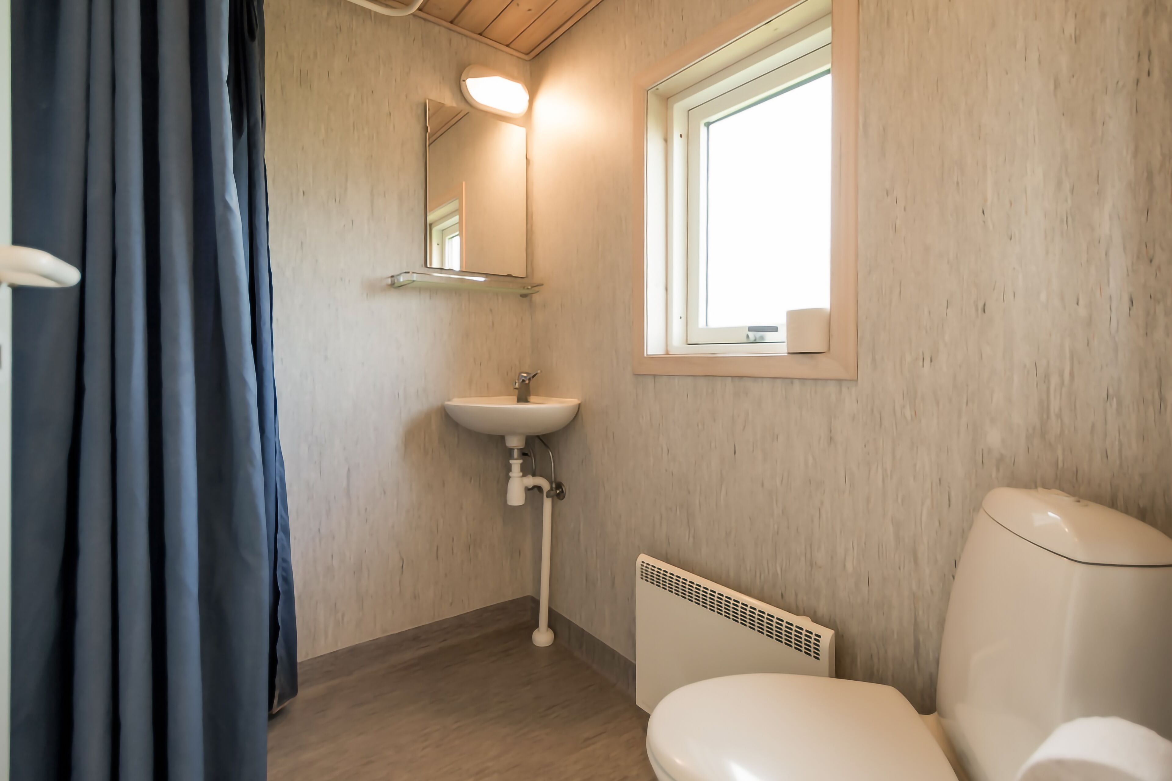 A bathroom with a white sink, a toilet, and a window.