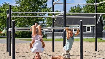 A playground with monkey bars and a sand area.