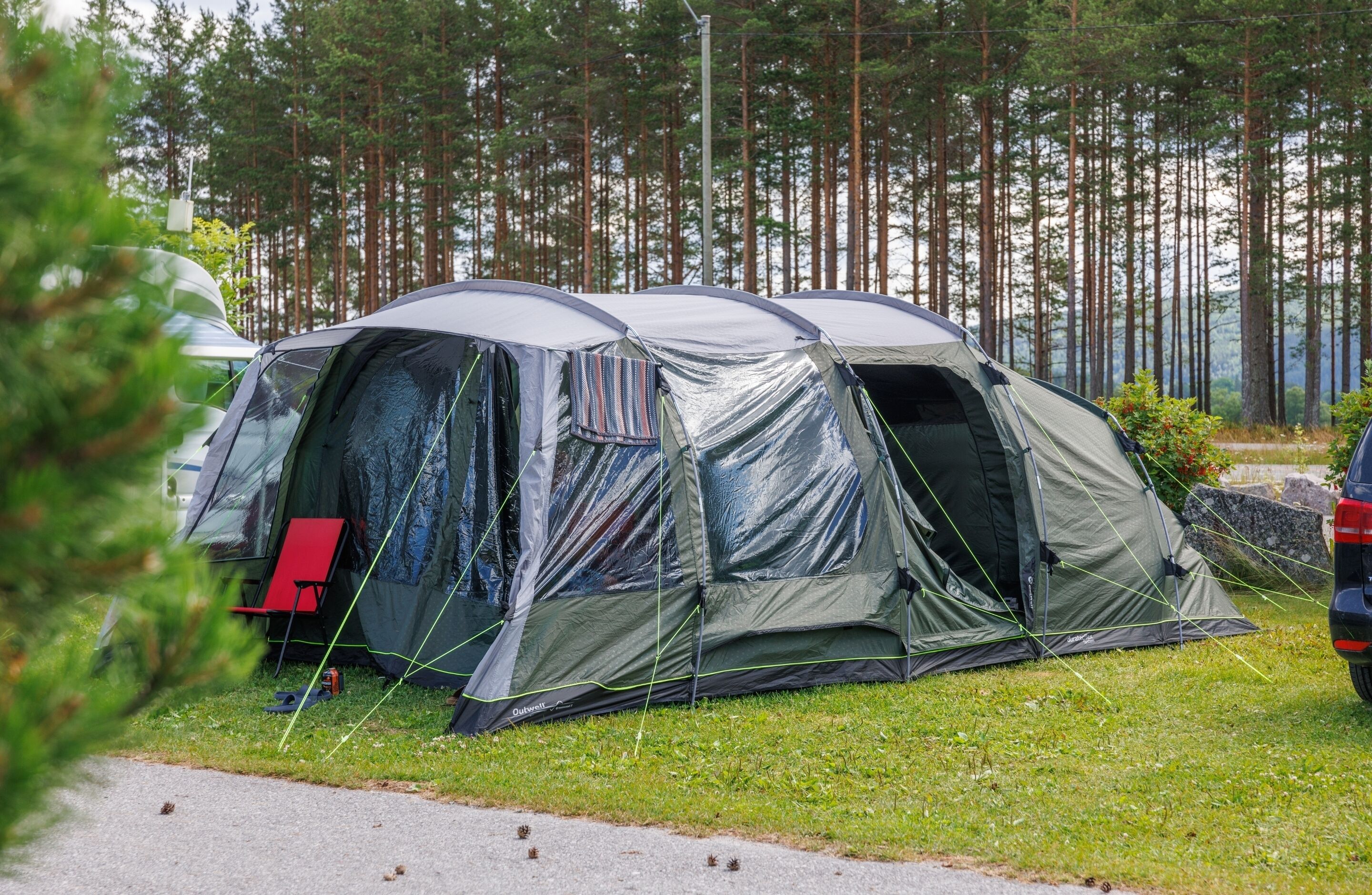 Leirintäalue, jossa on teltoja ja punainen tuoli.