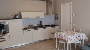 Una cocina compacta con comedor, un sofá y una puerta.