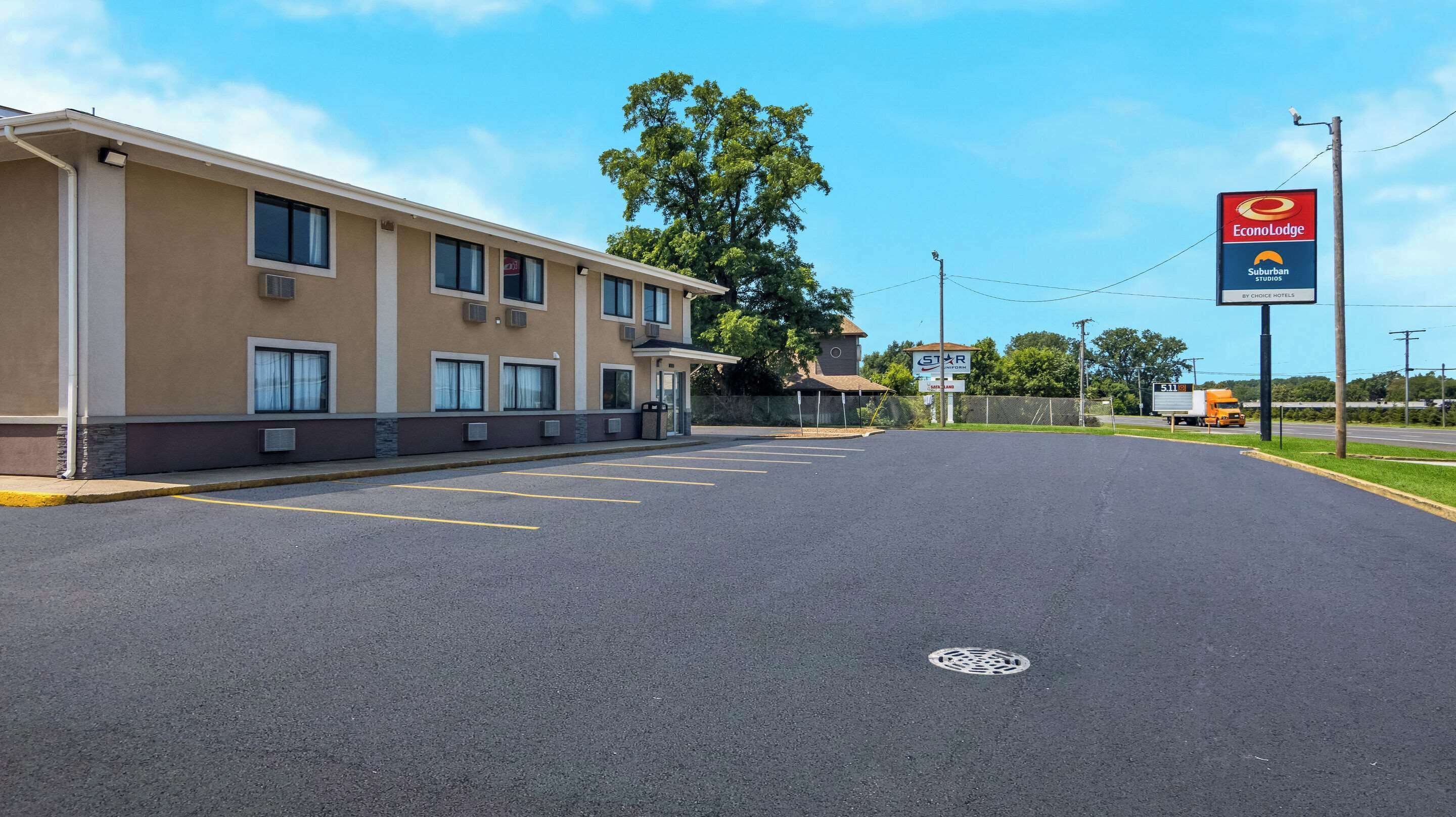 A hotel with a parking lot, a large tree, and a sign for EconoLodge.