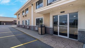 A building with a parking lot, a fire hydrant, and a trash can. - Econo Lodge Portage (Portage)