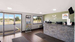 A reception area with a stone wall, a computer desk, and a window. - Econo Lodge Portage (Portage)