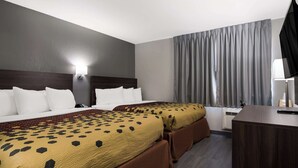 A hotel room with two beds, a desk, a lamp, and a window with curtains. - Econo Lodge Portage (Portage)