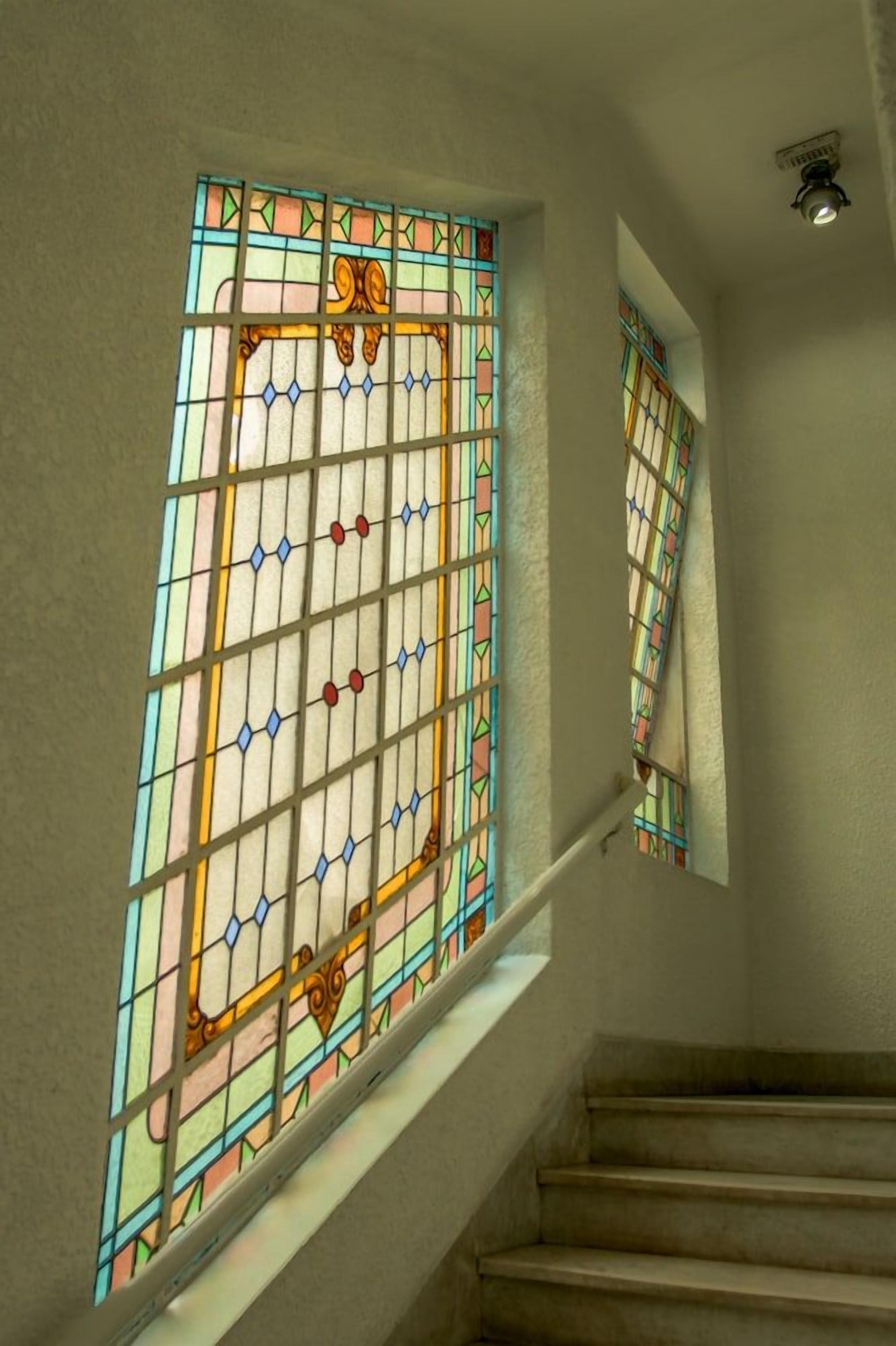 Escada com vitral na parede.