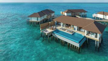Overwater bungalows with infinity pools, wooden deck areas, and clear ocean views.