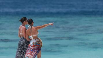 Dos personas en una playa con vista al océano.