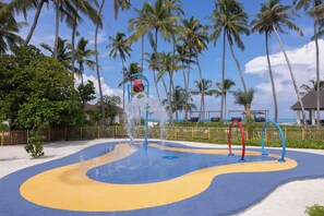 A water play area with a blue and yellow design, surrounded by palm trees and a wooden fence. - Avani+ Fares Maldives Resort (Fares)