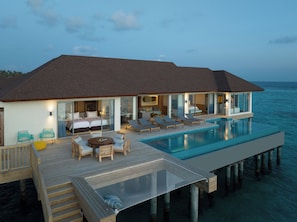 A modern overwater villa with a private infinity pool, multiple bedrooms, and a deck with outdoor seating. - Avani+ Fares Maldives Resort (Fares)