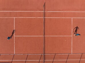 A tennis court with white boundary lines and a net. - Avani+ Fares Maldives Resort (Fares)