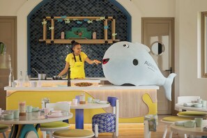 A restaurant with a large whale mascot, a chef preparing food, and a modern interior design. - Avani+ Fares Maldives Resort (Fares)
