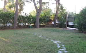Stroll through the serene garden, surrounded by lush greenery and shaded by trees.