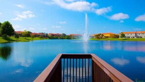 Un lago con una fontana, circondato da edifici con tetti rossi.