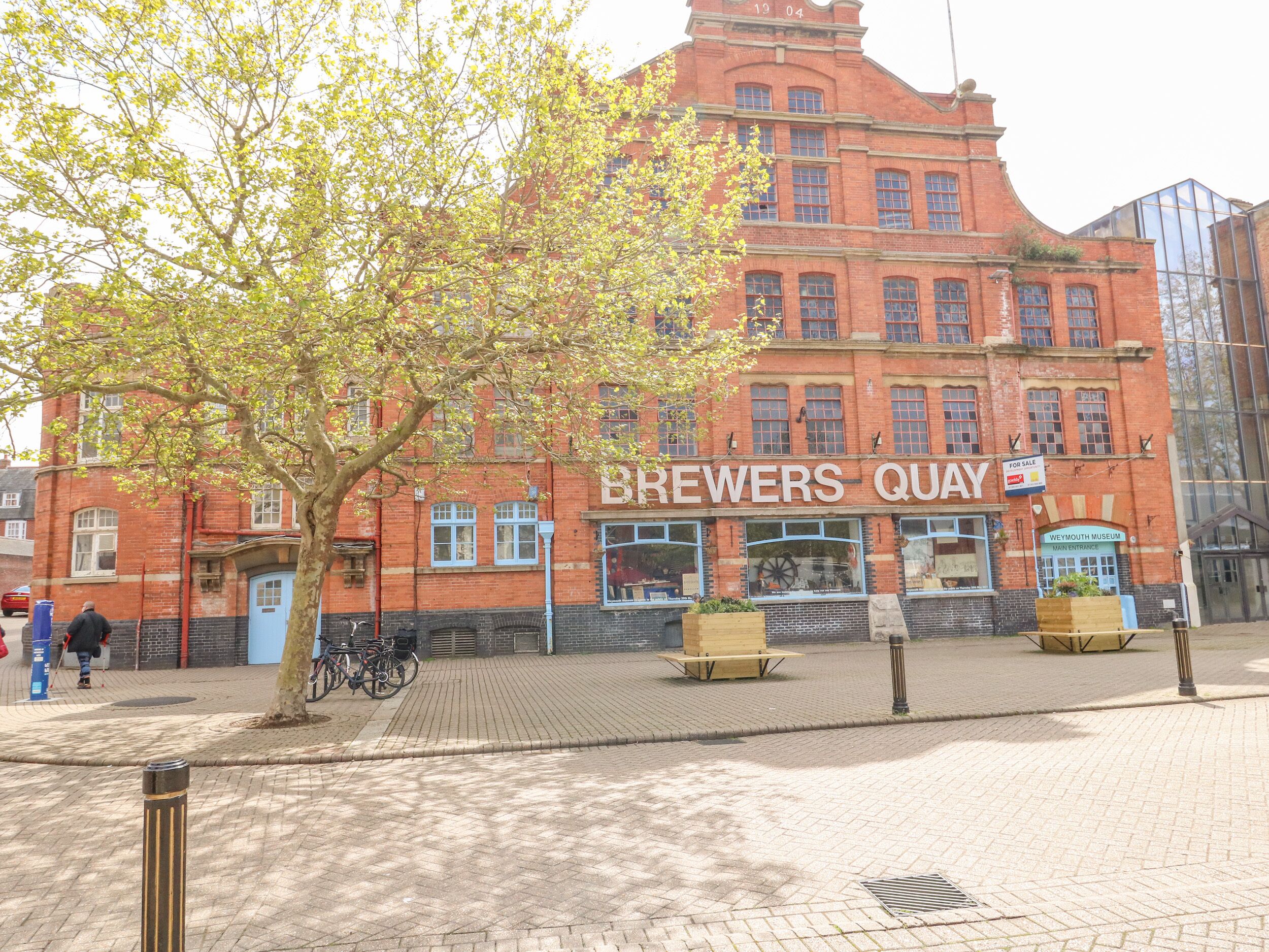 A red brick building with a sign reading "BREWERS QUAY" and a "Weymouth Museum" entrance.