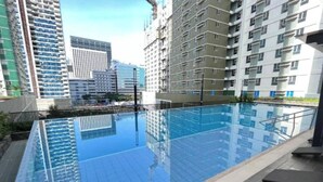 Una piscina en la azotea con vistas despejadas de los edificios altos circundantes.