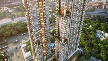 A high-rise residential building with multiple balconies, a central courtyard, and a view of the surrounding urban area.