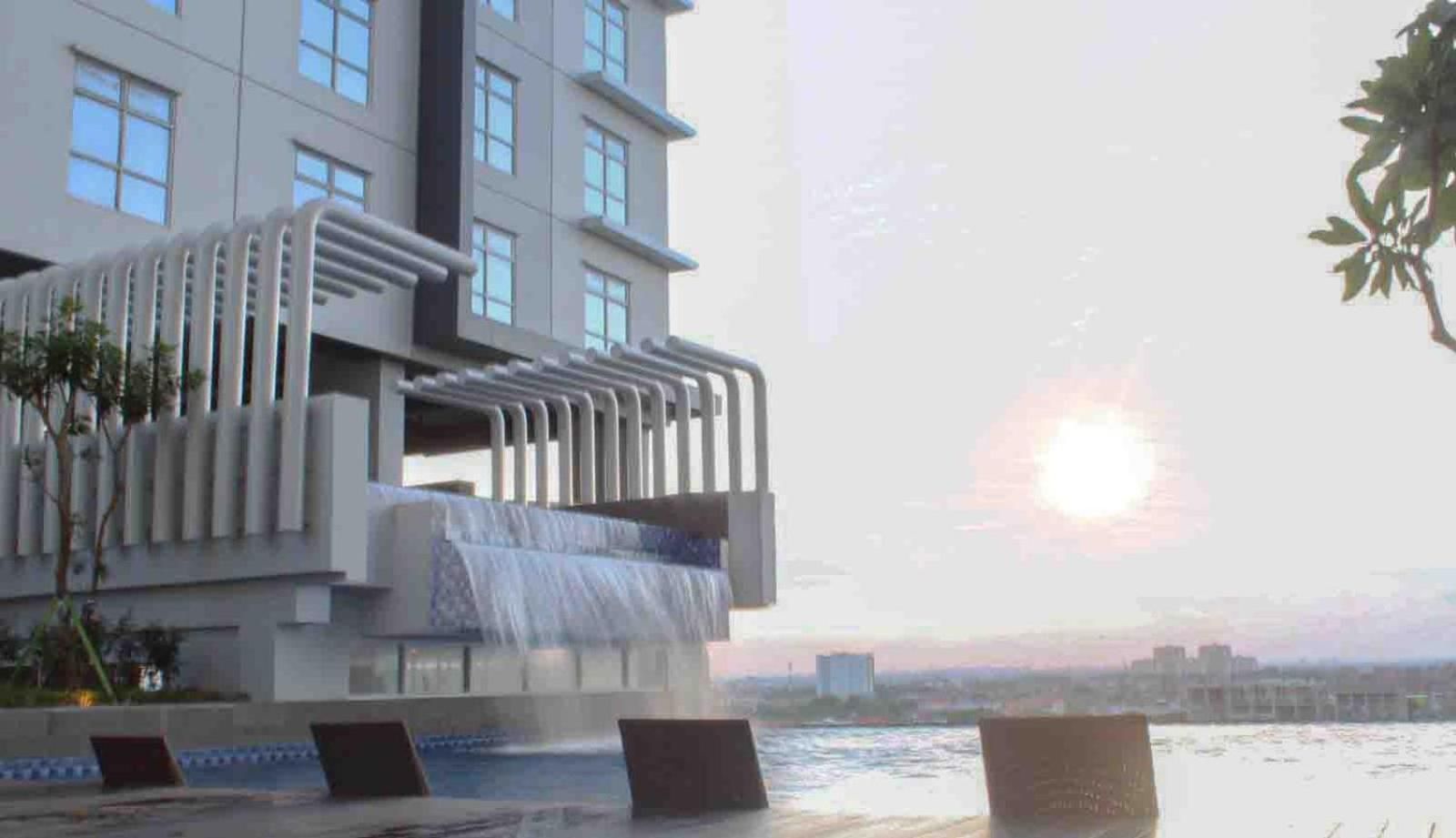 A modern building with a water feature and a view of the cityscape.