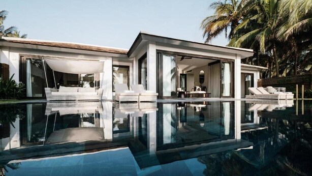 A modern house with a swimming pool, large glass doors, and outdoor seating areas. - TIA Wellness Resort (Da Nang Municipality)