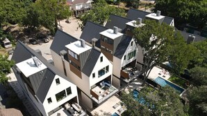 A modern residential complex with multiple houses, a shared swimming pool, and a landscaped garden.
