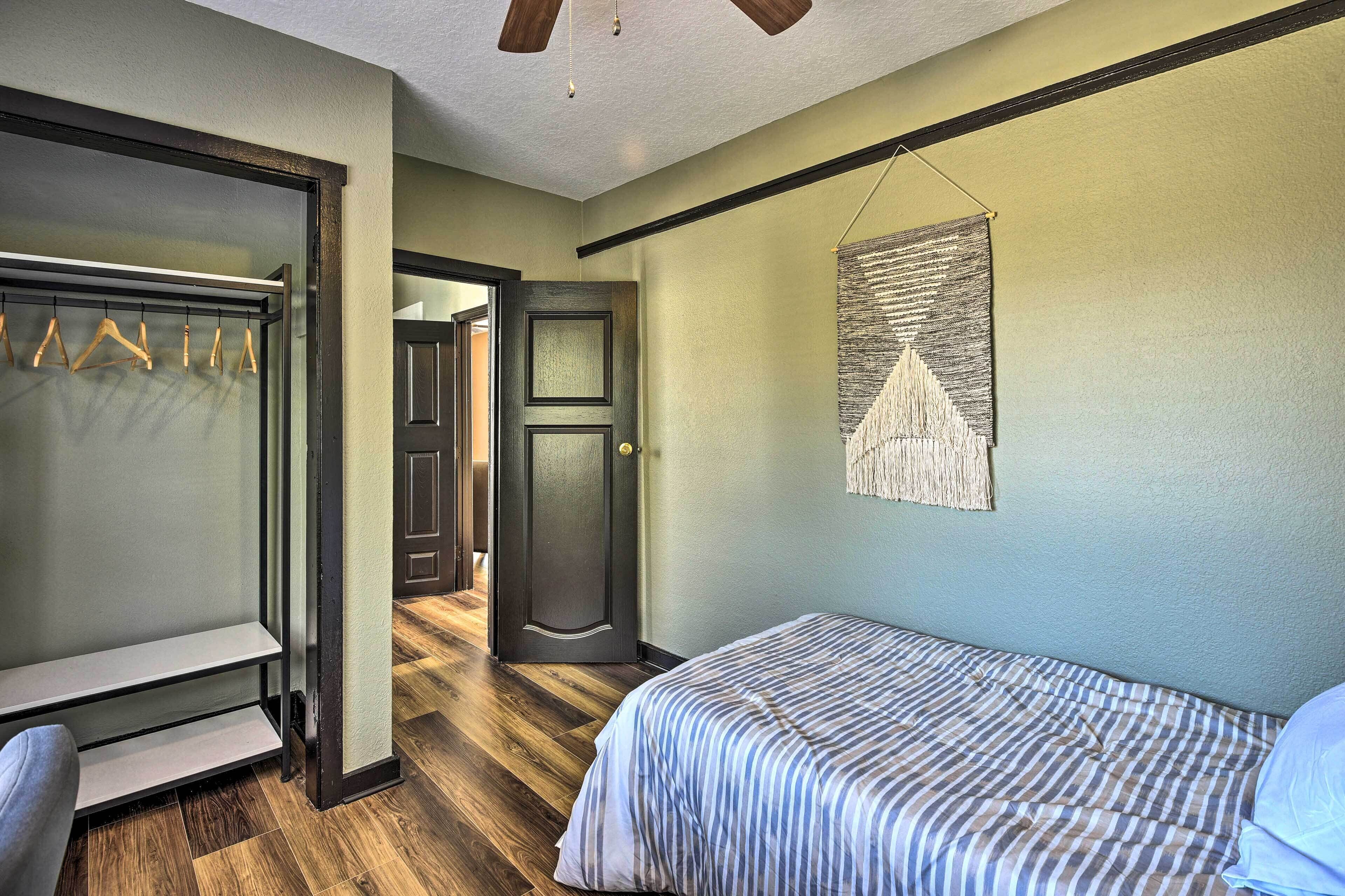 A bedroom with a bed, a wardrobe, and a door leading to another room.