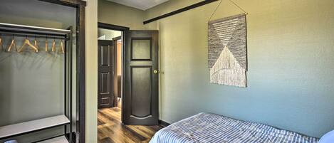 A bedroom with a bed, a wardrobe, and a door leading to another room.