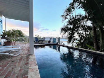 Pool deck surrounded by lush landscaping