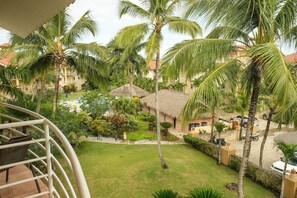 Ein Resort mit Pool, Palmen und strohgedeckten Gebäuden.