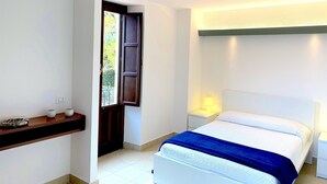 Une chambre à coucher comprenant un lit, des tables de chevet, une commode, une fenêtre et une étagère avec des objets décoratifs.