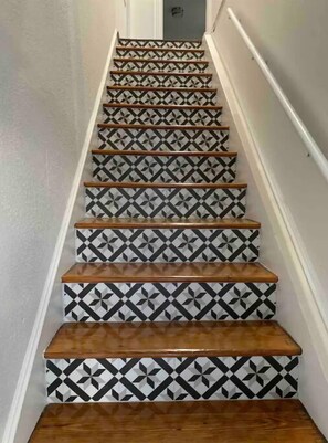 Staircase features a striking geometric pattern on the steps and wooden handrails.
