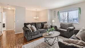 A living room with a grey sofa set, a coffee table, and a chandelier. - Centrally located for adventures (Westminster)
