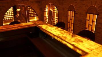 A room with a long counter, arched windows, and a statue.